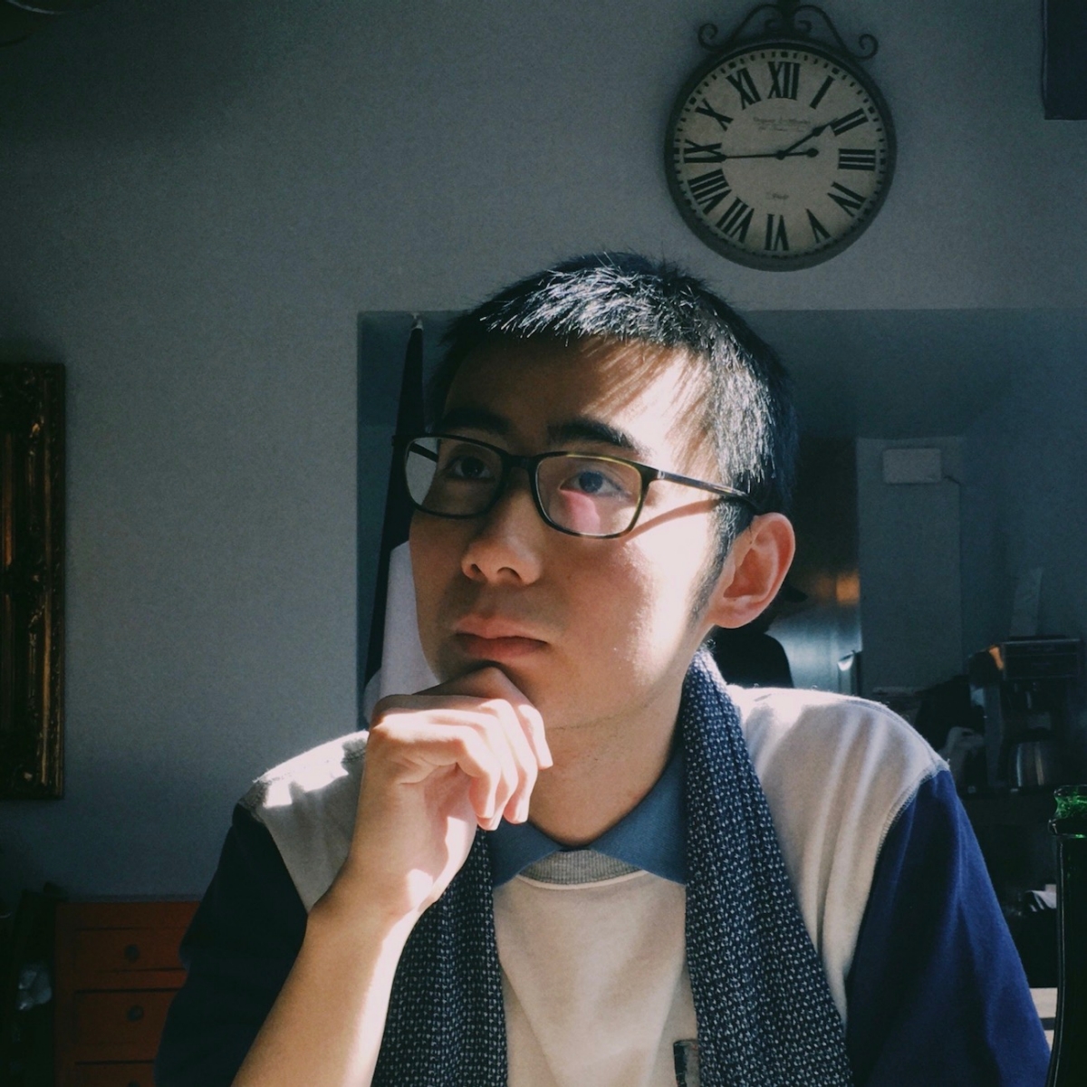 Zhen Yu (Victor) Yao wears glasses and a multicolor shirt, looking away from the camera.